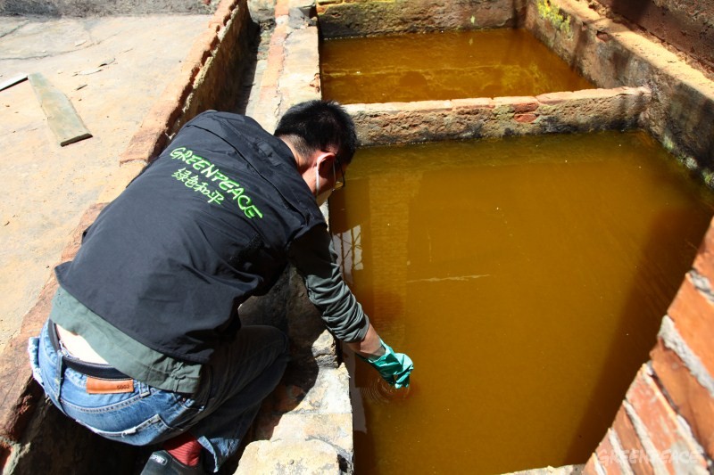 08-绿色和平工作人员在云南牟定渝滇化工有限公司厂区内对铬渣堆附近的废水收集池内的废水进行取样和快速检测。