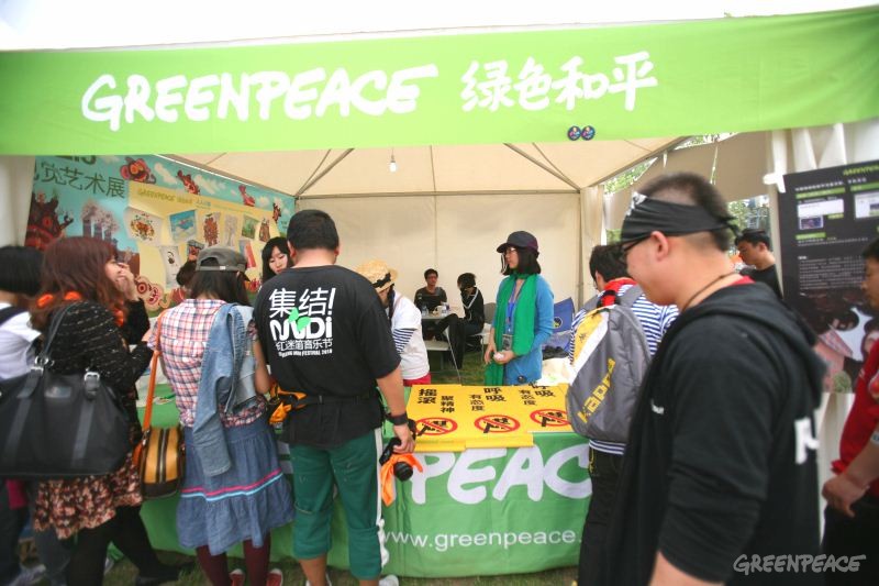 乐迷到绿色和平的展位领取“减少用煤”的纹身贴纸
