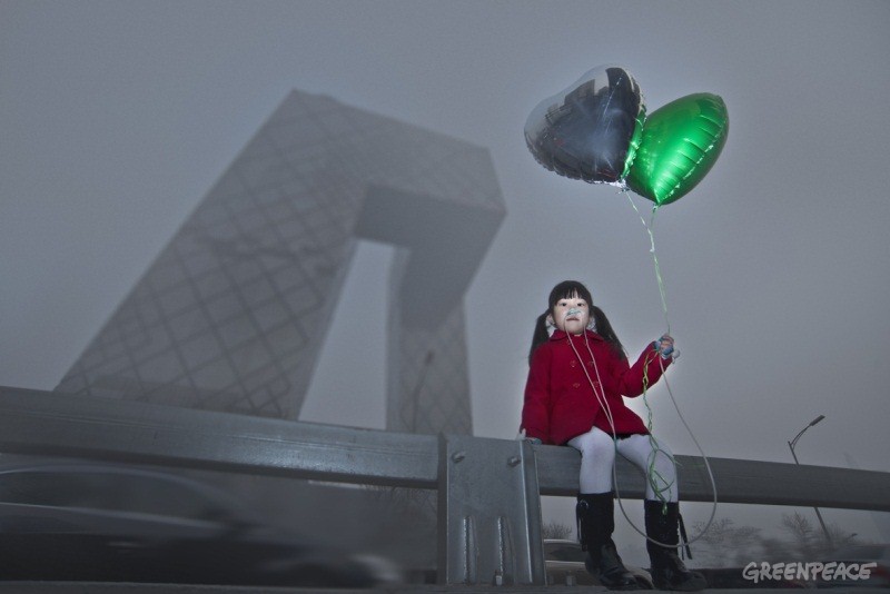 一个小女孩手持气球在污染的空气中
